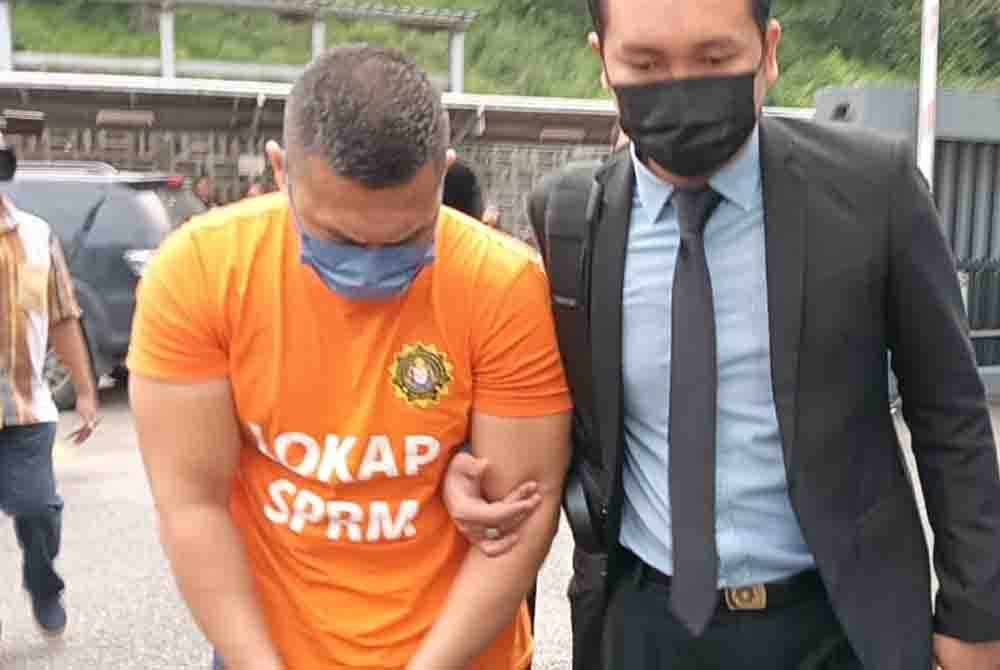 Suspek tiba di pekarangan mahkamah dengan berpakaian lokap SPRM dan tangan bergari kira-kira jam 9 pagi.