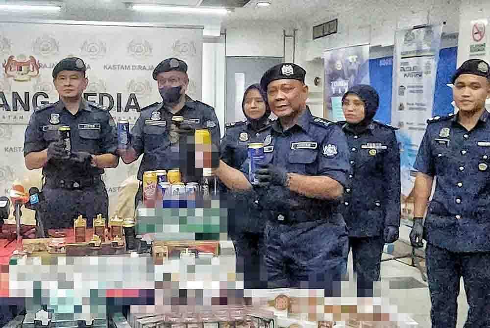 Nadzri (empat, kiri) menunjukkan sebahagian minuman keras tidak bercukai yang dirampas dalam serbuan dilakukan pihaknya.