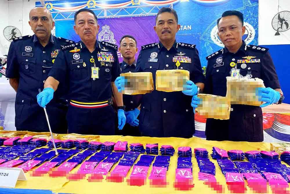 Muhamad Zaki (dua,kiri) menunjukkan sebahagian daripada pil yaba yang dirampas dalam serbuan di Batu 4 Jalan Pasir Mas-Salor di sini pada Ahad lalu.