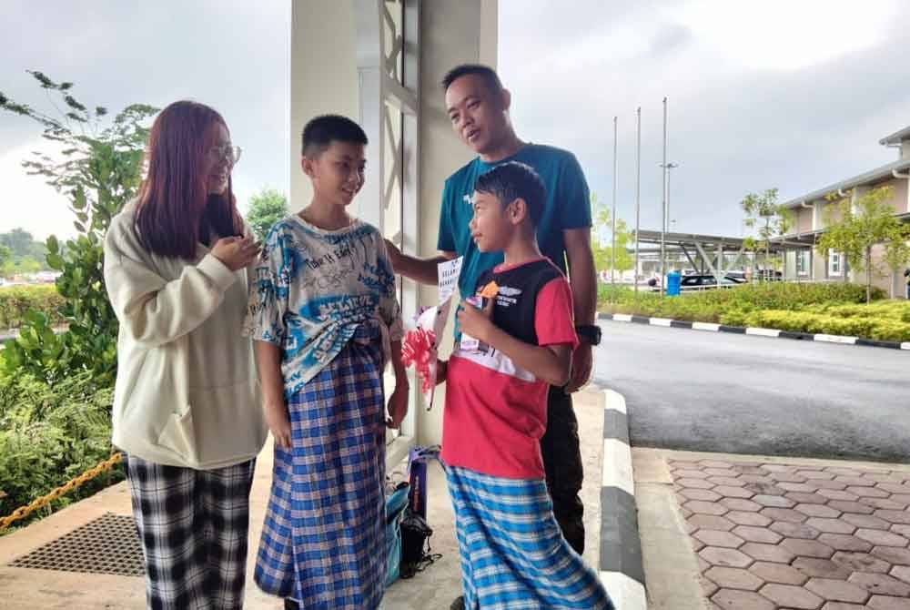 Koh Ming Zhe (tengah) berbual dengan seorang peserta Program Khatan Perdana, Aidil Putra Rashidi, 9, ketika Program Khatan Perdana Hospital Tanah Merah.