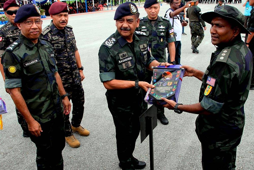 Razarudin (dua, kanan) menyampaikan sijil penghargaan dan penyertaan kepada wakil peserta pada Majlis Perasmian Penutupan Ujian Mara Lasak KDNKA 2024 di Padang Kawad Markas Briged Utara Pasukan Gerakan Am, Ulu Kinta, pada Rabu. Foto Bernama