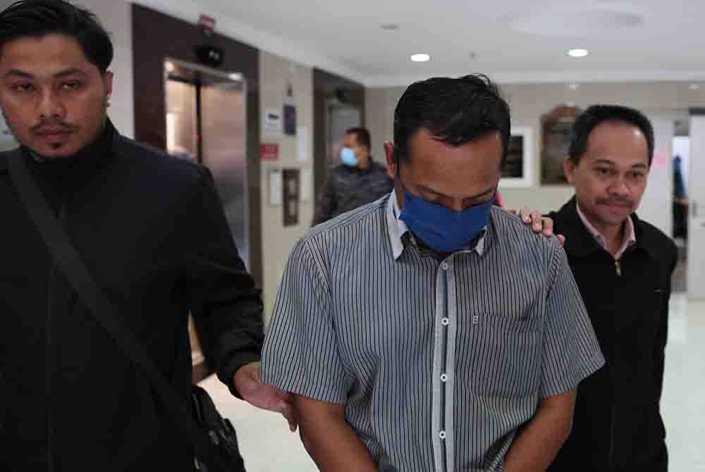 Tertuduh (tengah) didapati bersalah atas dakwaan salah guna kuasa.