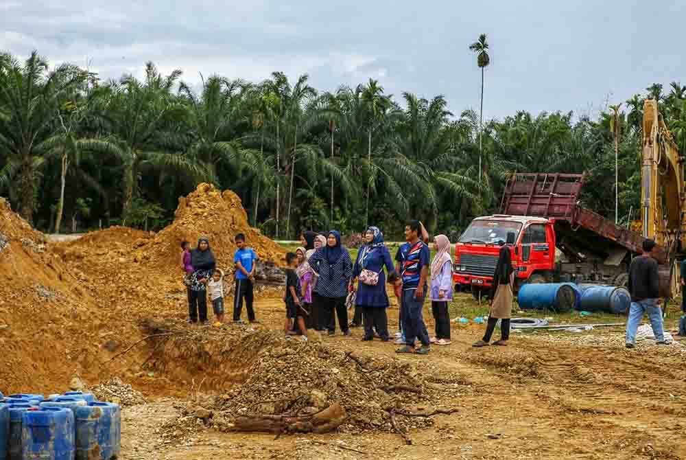 Penduduk sedang meninjau keadaan di tapak projek menyedut pasir pada petang Rabu.