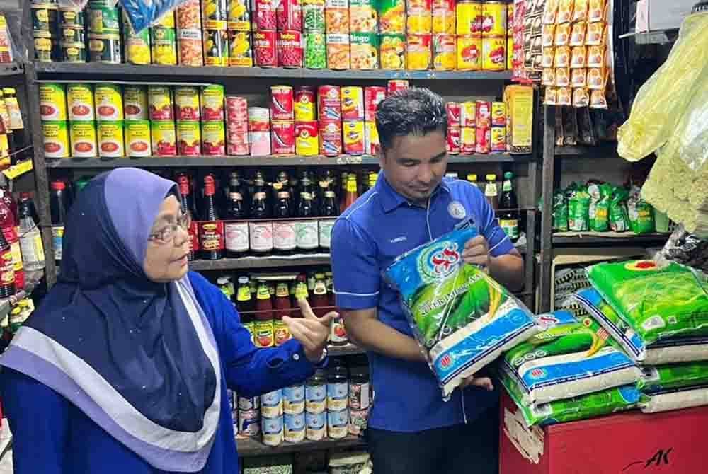 Yusrizal (kanan) ketika meninjau jualan beras di kedai runcit Pasar Besar Alor Setar pada Khamis.