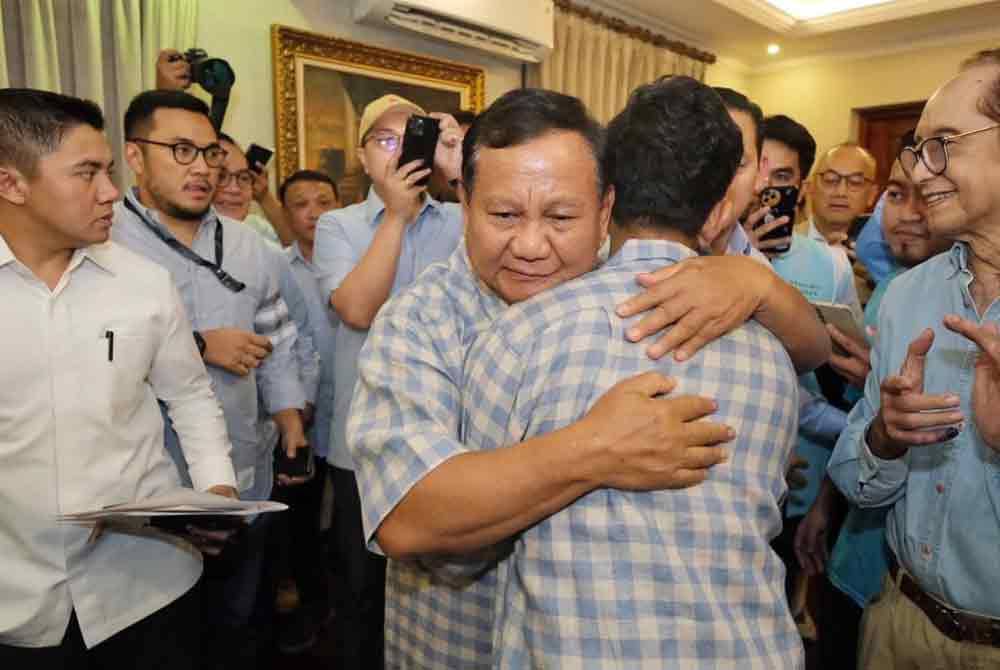 Prabowo memeluk erat gandingannya, Gibran selepas 'quick count' menunjukkan mereka mendahului saingan Pilpres Indonesia 2024.