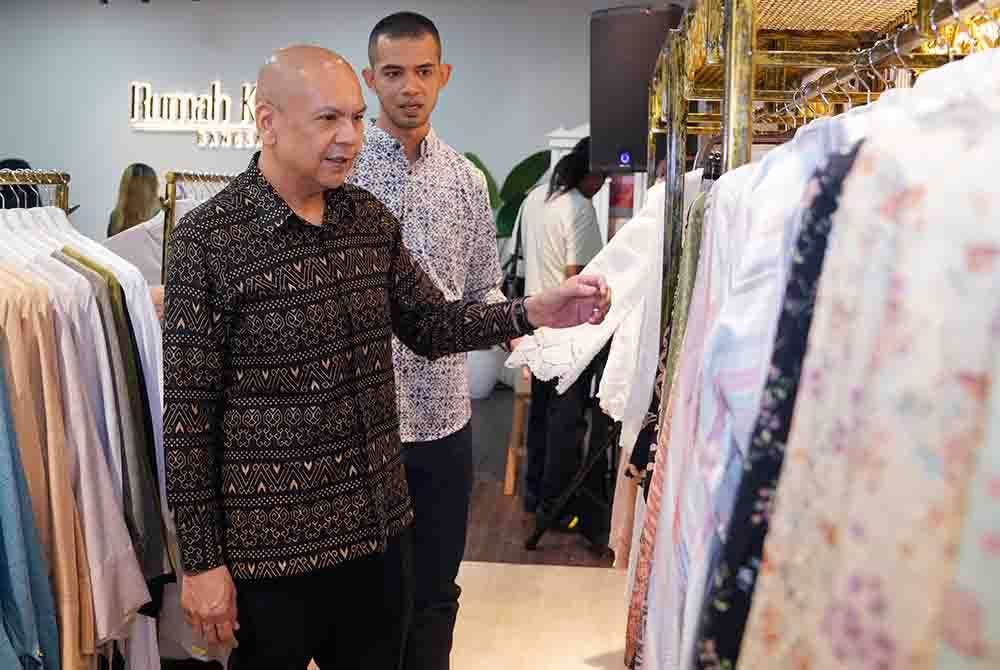 Armizan (hadapan) ditemani pengusaha RKB, Zul Izwan melihat koleksi busana yang dijual di butik itu pada Jumaat.