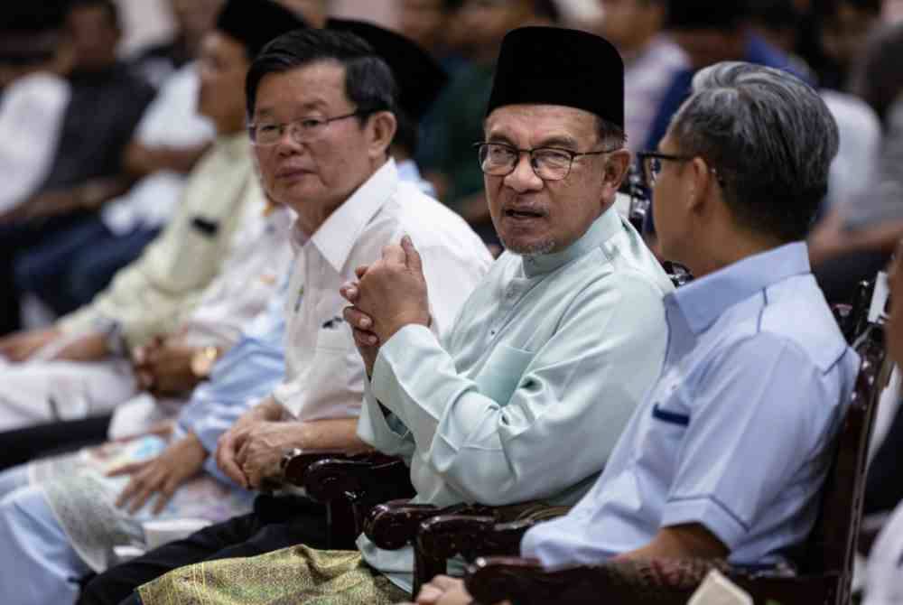 Anwar berbincang bersama Fahmi (kanan) ketika menghadiri Karnival Pemerkasaan Kesalinghubungan dan Pembangunan Usahawan Pulau Pinang di Politeknik Seberang Perai pada Jumaat. Turut hadir Kon Yeow (kiri). Foto Bernama