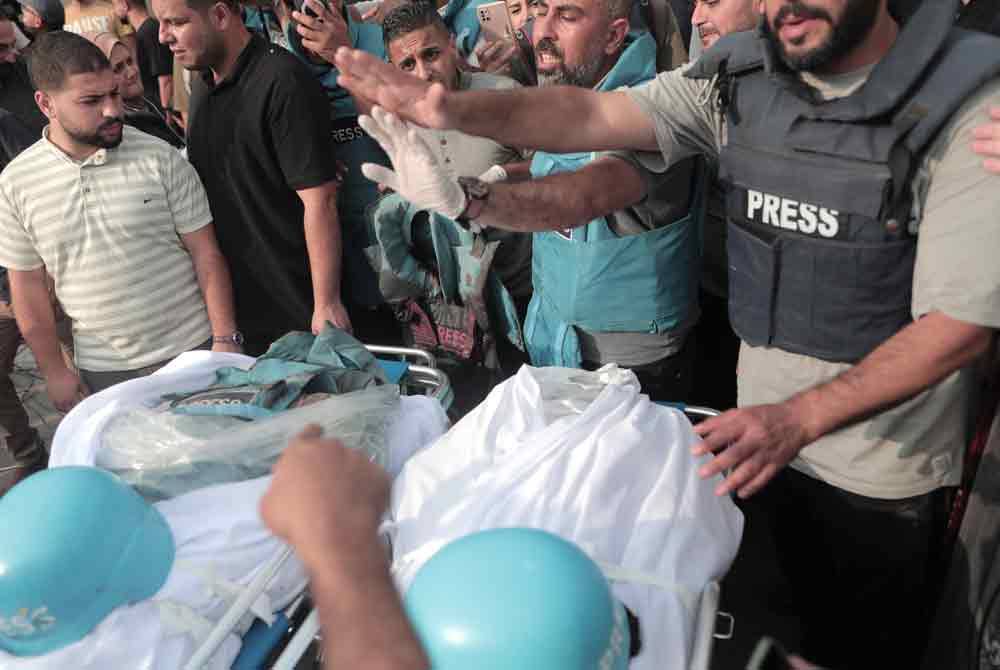 Segelintir penduduk Palestin menghadiri solat jenazah dua wartawan dikenali sebagai Said al-Taweel dan Mohammed Sobboh yang terkorban dalam serangan udara tentera Israel di Gaza City. - AFP