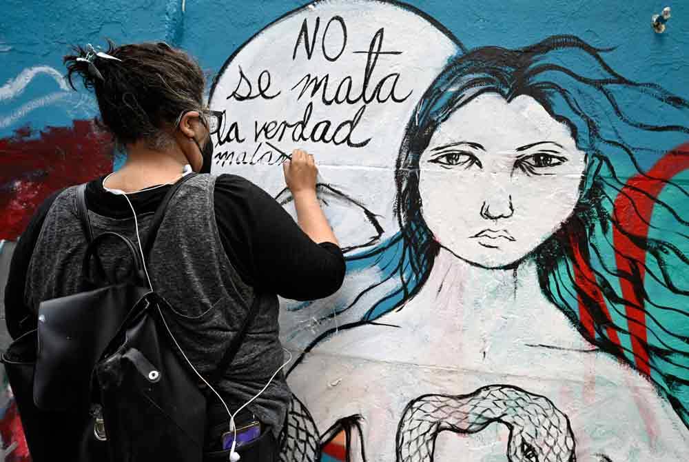 Seorang artis sedang melukis mural dinding sebagai protes pembunuhan enam wartawan di Mexico sejak permulaan tahun 2022. - AFP
