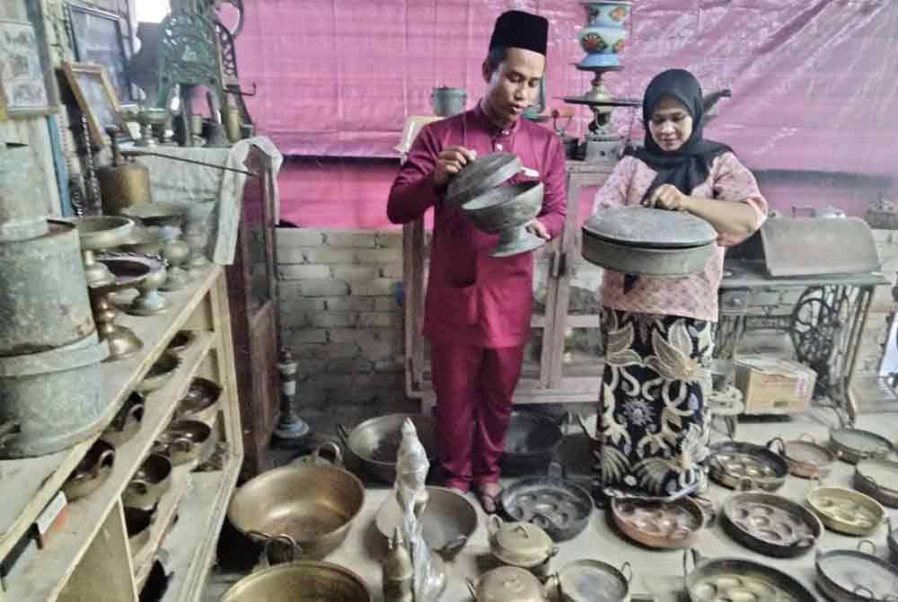 Mohd Zulhilmi dan Normimi Suhana menunjukkan barangan tembaga di rumah mereka.