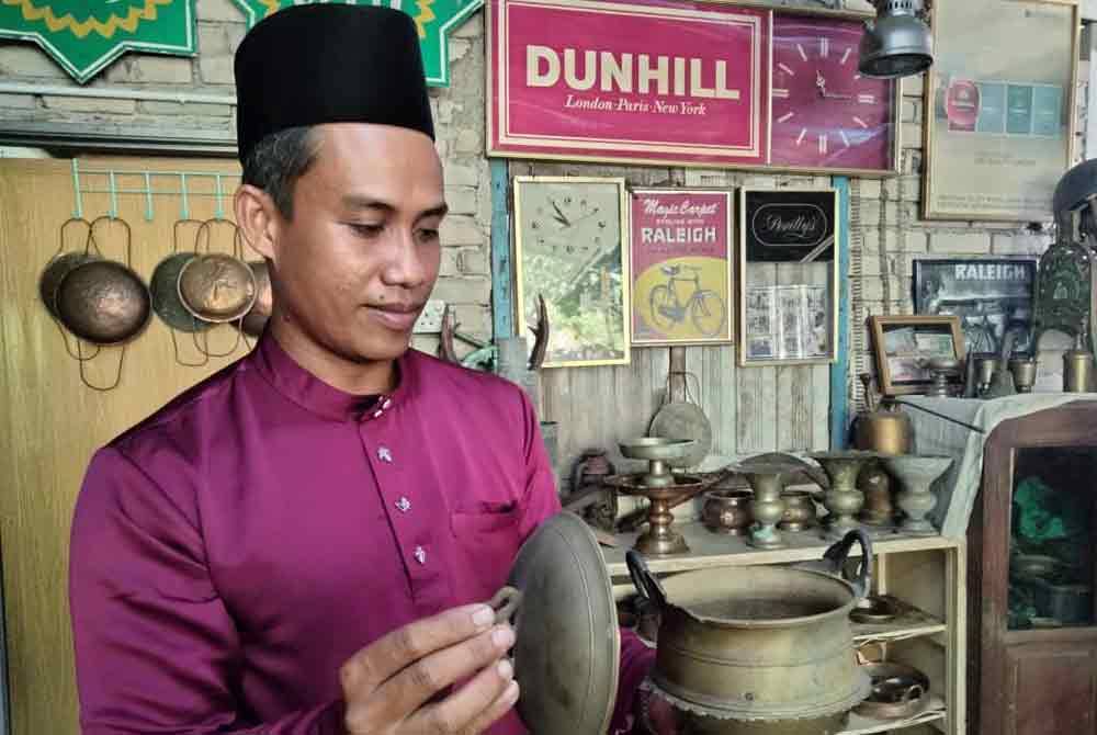 Mohd Zulhilmi menunjukkan periuk bertapak yang menjadi koleksi tembaga kesayangannya.