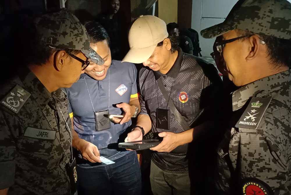 Jafri (kiri) bersama anggota dan pegawai Jabatan Pendaftaran Negara serta Jabatan Imigresen Malaysia Selangor memeriksa dokumen warga asing yang ditahan dalam serbuan pada Ahad.