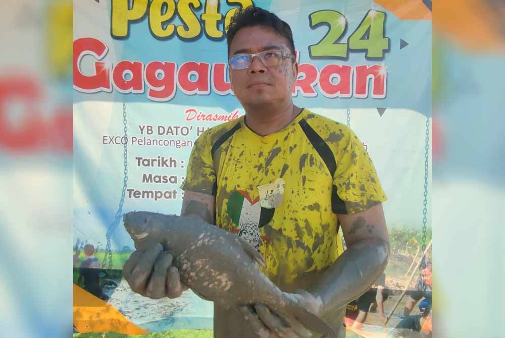 Mohd Azhar menunjukkan ikan berjaya ditangkap menggunakan tangan.