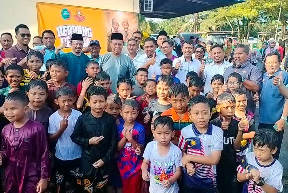 Hasni (tengah) bergambar bersama peserta program berkhatan 'Gerbang Remaja' di Kompleks Penghulu Mukim Sungai Pinggan, Benut pada Ahad.