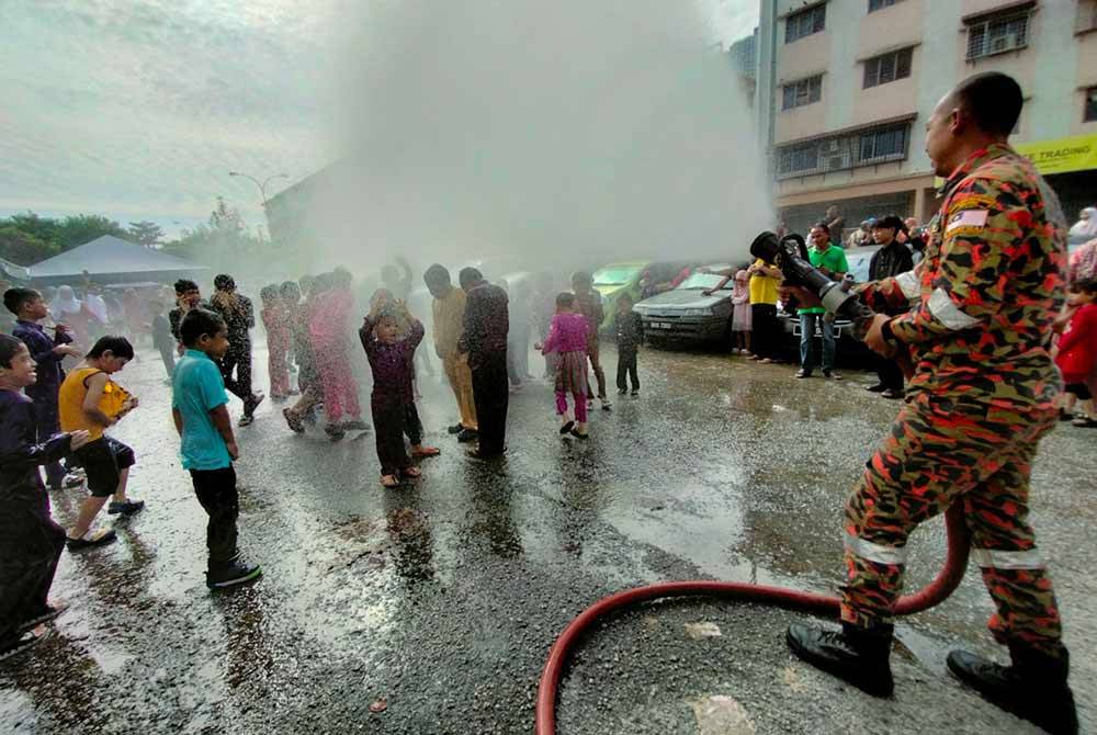 Kanak-kanak terbabit dibawa berarak sebelum disembur dengan air pancut JBPM