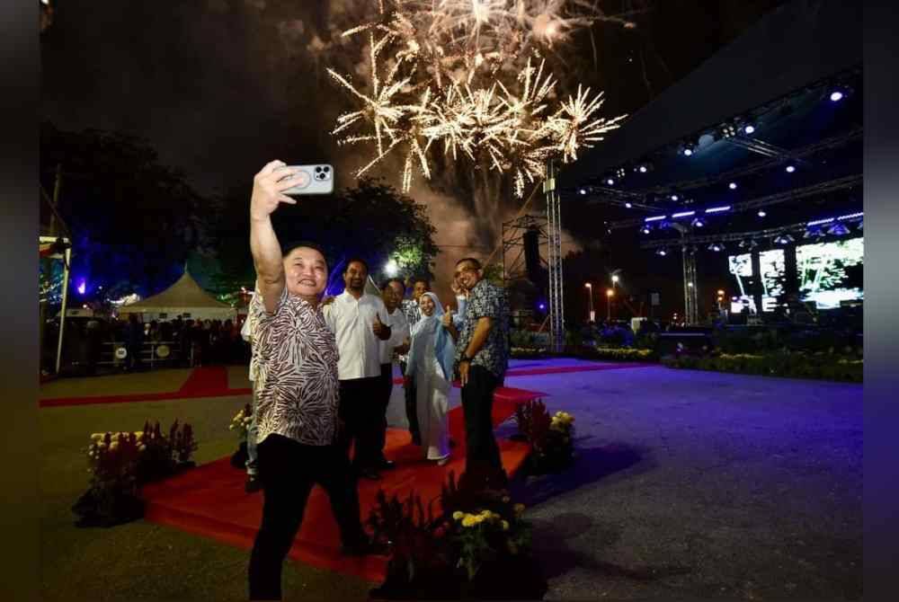 
Suee Lim (kiri) bergambar bersama tetamu kenamaan berlatar belakang pertunjukan bunga api sempena perasmian Karnival Bandaraya Diraja Klang pada Sabtu.