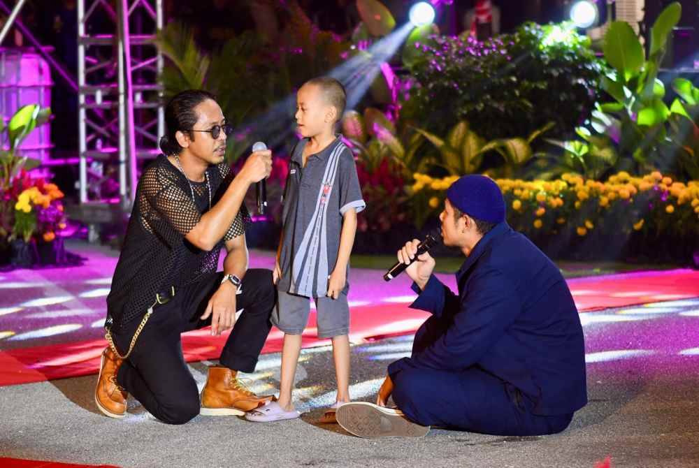 Hazama (kiri) dan Nabil (kanan) beramah mesra bersama seorang penonton cilik pada malam perasmian Karnival Bandaraya Diraja Klang.