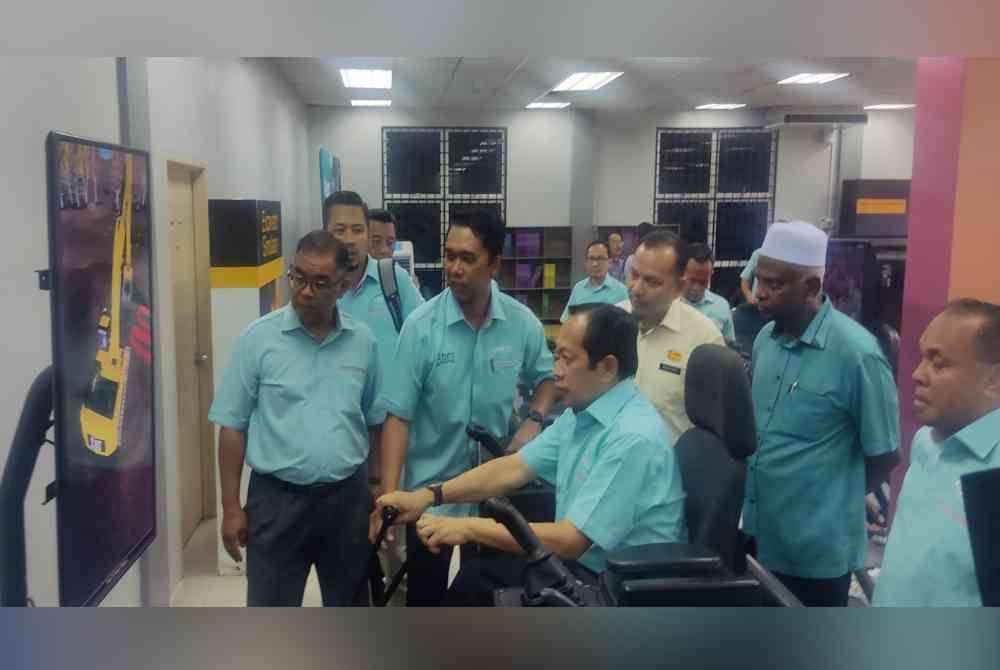 Ahmad (duduk) mencuba modul pembelajaran simulasi jentera berat semasa melawat ABM Wilayah Utara di Sintok pada Ahad.