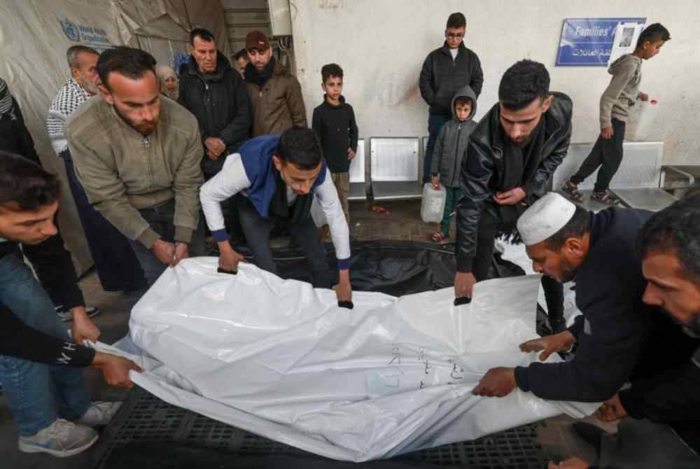 Rakyat Palestin menguruskan jenazah mangsa berikutan serangan bom Israel ke atas Rafah di selatan Semenanjung Gaza, di hospital al-Najar pada Jumaat, di tengah-tengah pertempuran berterusan antara Zionis Israel dan pejuang Hamas. Foto AFP