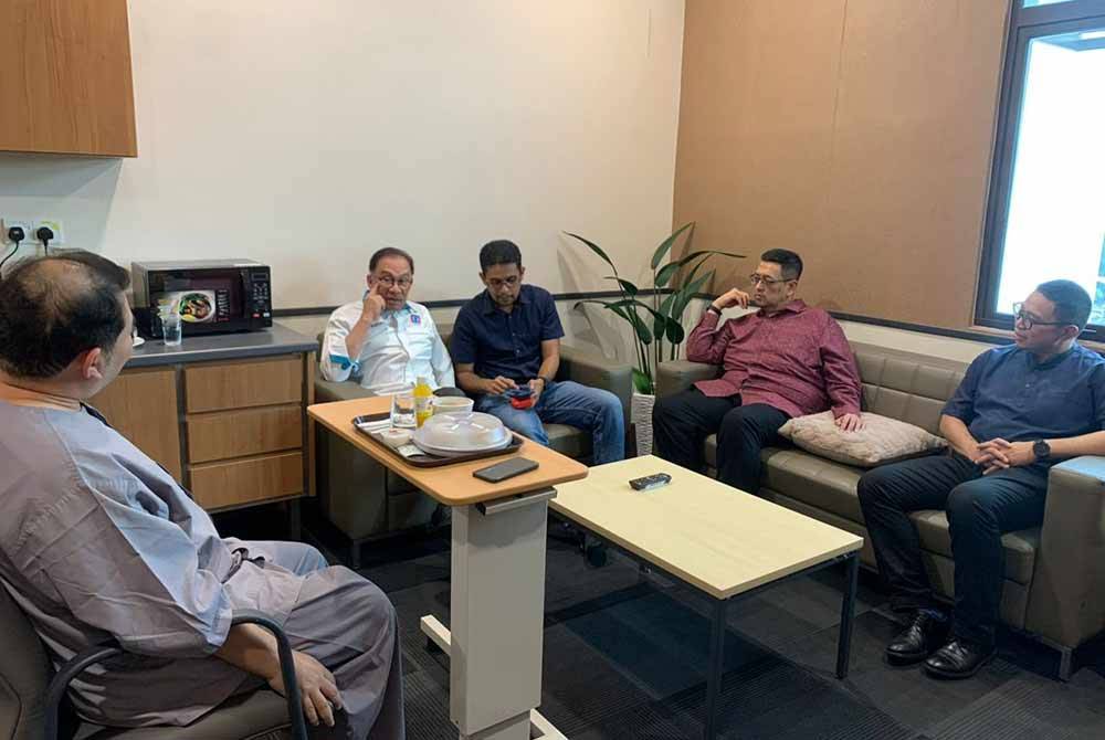 Anwar (dua dari kiri) ketika menziarahi Rafizi (kiri) yang sedang dirawat di hospital. Foto X Anwar Ibrahim