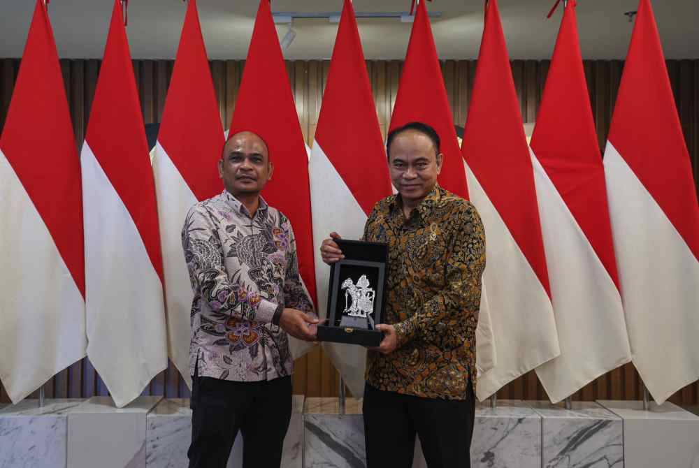 Budi (kanan) menyerahkan cenderamata kepada Setiausaha Agung Iswani Malaysia, Mohd Shukri Ishak.