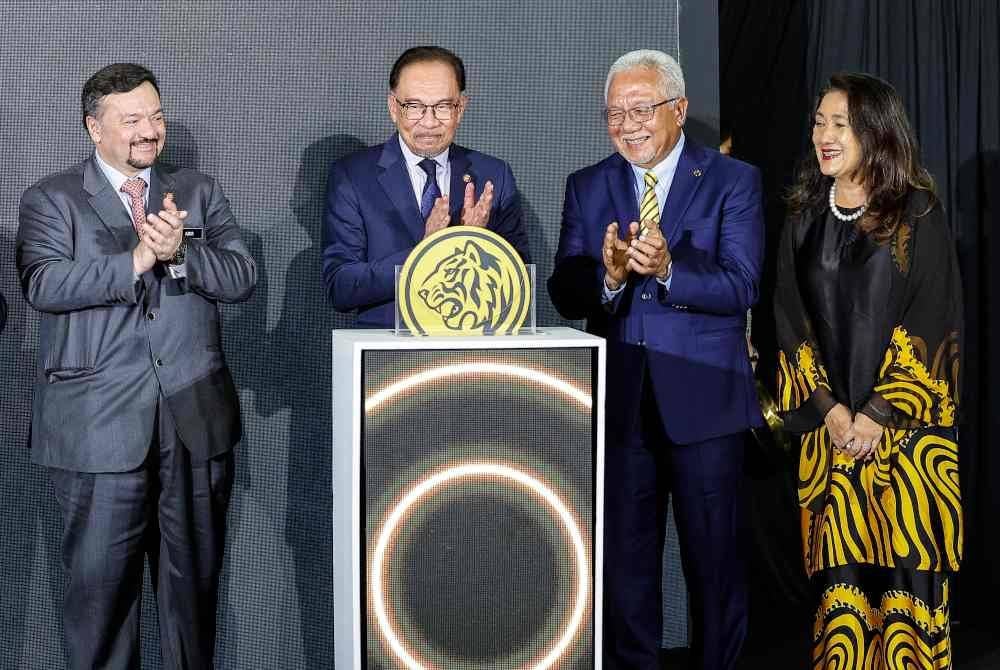 Anwar (dua dari kiri) bersama Pengerusi Kumpulan Maybank Tan Sri Ir Zamzamzairani Mohd Isa (dua, kanan) pada pelancaran Program Memperkasakan PKS, 'myimpact SME Hub', pada Majlis Ramah Mesra Perdana Menteri Bersama Warga Maybank, di Menara Maybank, hari ini. - Bernama