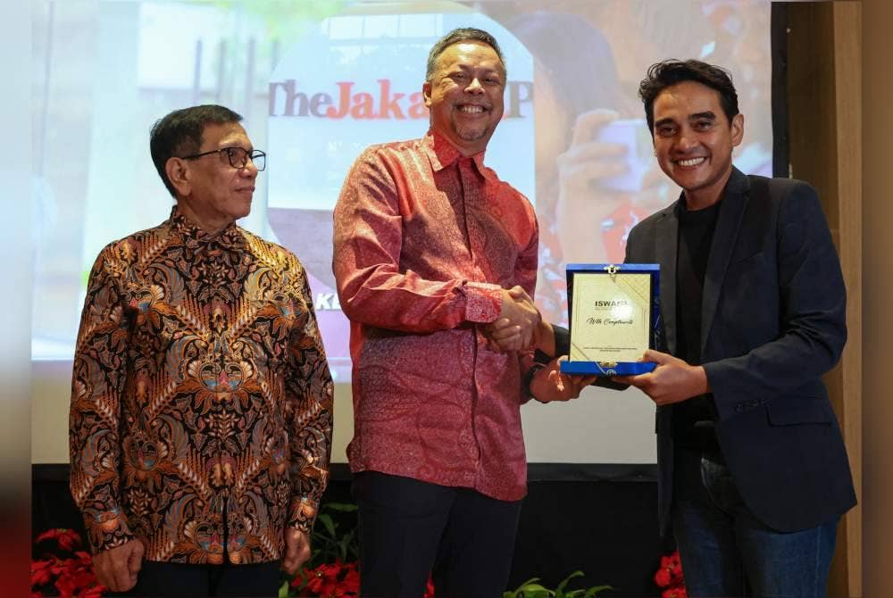 Duta Besar Malaysia ke Indonesia, Datuk Syed Mohamad Hasrin Tengku Hussin menerima cenderahati daripada Presiden Iswamiyang juga Ketua Pengarang ASTRO Awani, Ashwad Ismail (kanan) selepas Majlis Makan Malam Iswami bersama Duta Besar Malaysia di Indonesia di sebuah hotel di Ancol, pada Isnin. Turut hadir, Ketua Umum Persatuan Wartawan Indonesia (PWI Pusat), Hendry Ch Bangun (kiri). Foto Bernama