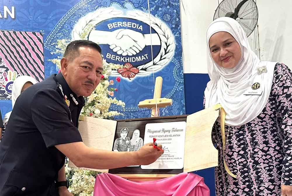 Muhamad Zaki (kiri) menurunkan tandatangan sempena Perasmian Mesyuarat Agung Perkep.