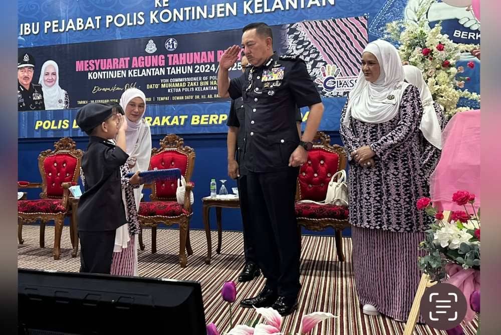 Muhamad Zaki (tengah) menyambut tabik hormat daripada ‘anggota polis cilik’ pada simbolik Perasmian Mesyuarat Agung Perkep Kontinjen Kelantan.
