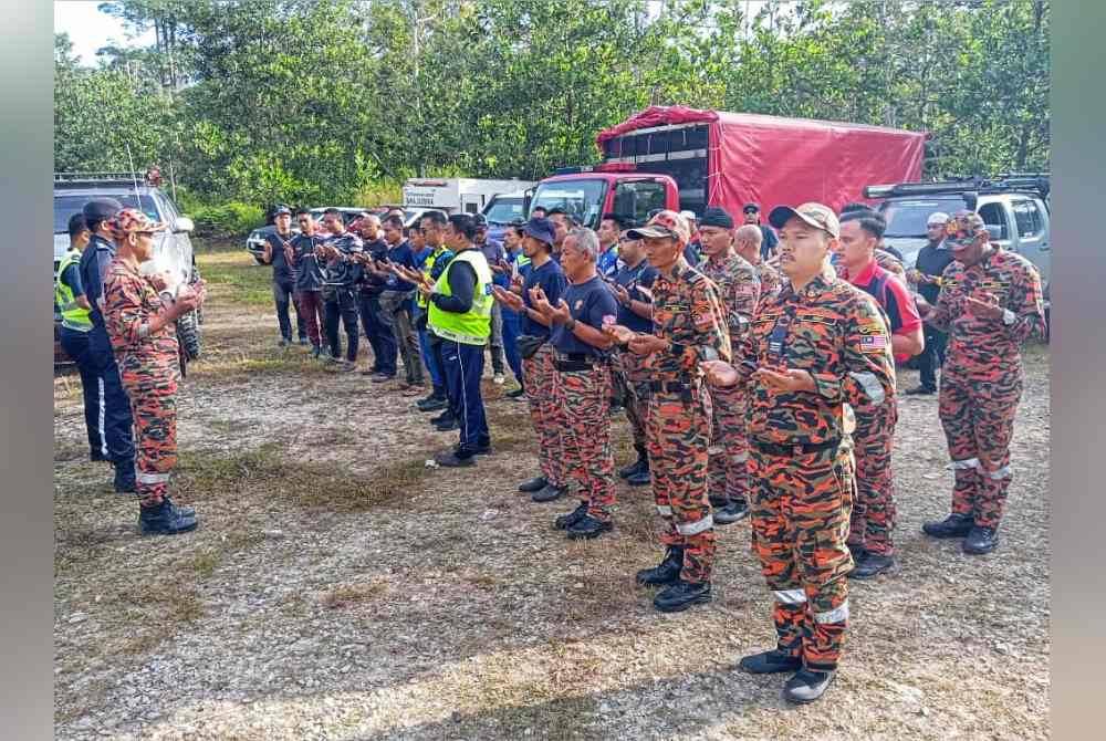 Anggota yang terlibat dalam SAR berdoa sebelum memulakan pencarian mangsa di lokasi kejadian. Foto Ihsan JBPM