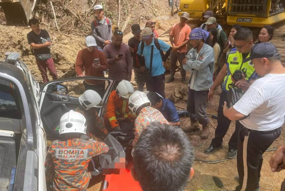 Pasukan bomba melakukan operasi mengeluarkan mangsa yang tersepit dalam kenderaan selepas dihempap batu dari atas bukit di Kampung Kuala Tomani, Mansaam, Tenom. Foto: Bomba