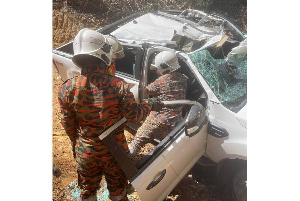 Pasukan bomba mengeluarkan mangsa yang tersepit dalam kenderaan selepas dihempap batu dari atas bukit di Kampung Kuala Tomani, Mansaam, Tenom. Foto: Bomba