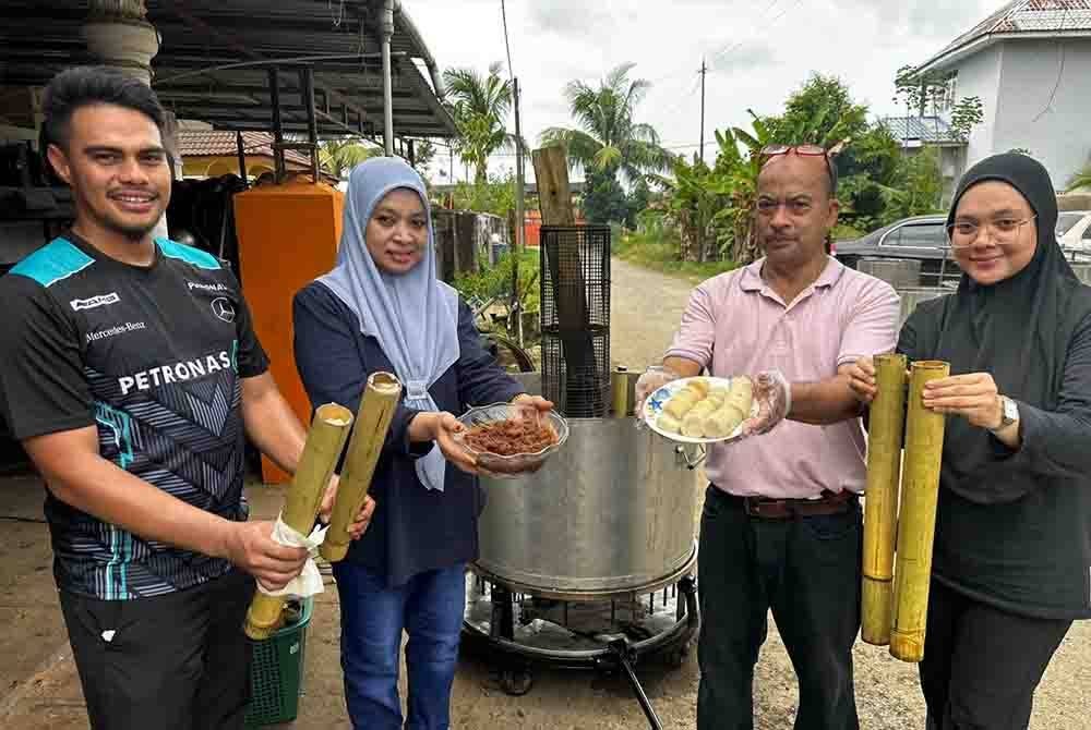 Fauzi (dua dari kanan) bersama ahli keluarganya menunjukkan lemang yang dihasilkan daripada mesin membakar lemang automatik.