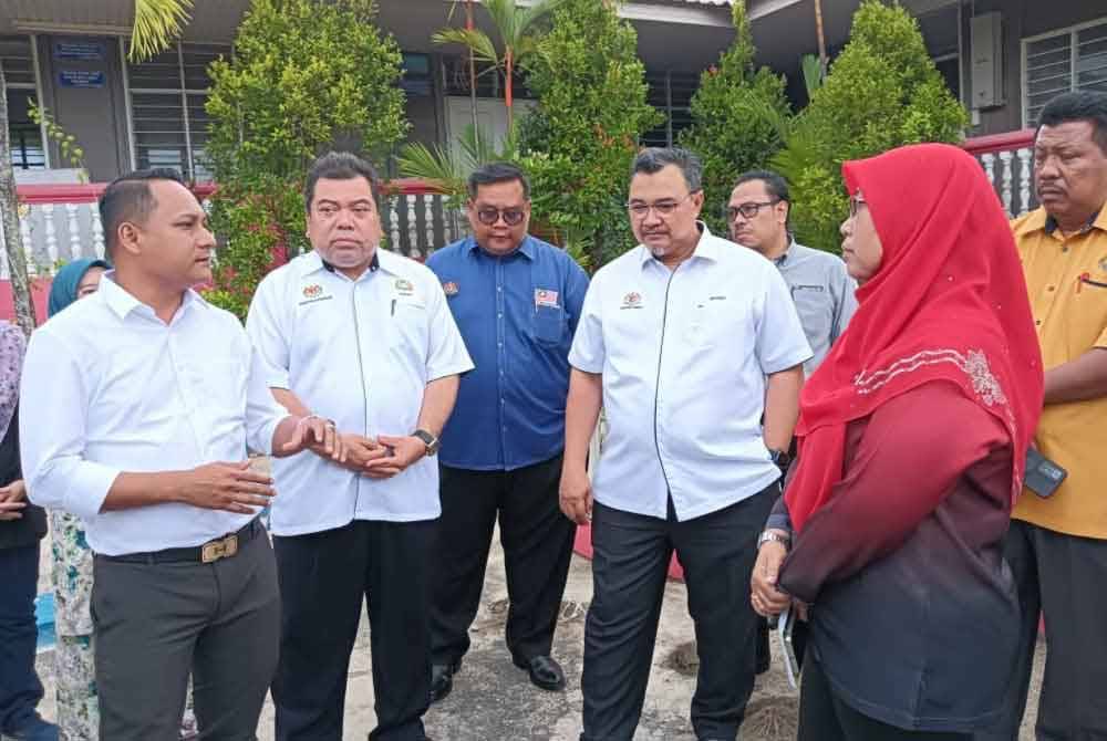 Aznan (kiri) bersama-sama Mohd Hanafi dan wakil Jabatan Pendidikan Negeri Johor berbincang mengenai pembinaan sekolah baharu atas tapak SK Perigi Acheh, Pasir Gudang pada lewat petang Rabu.