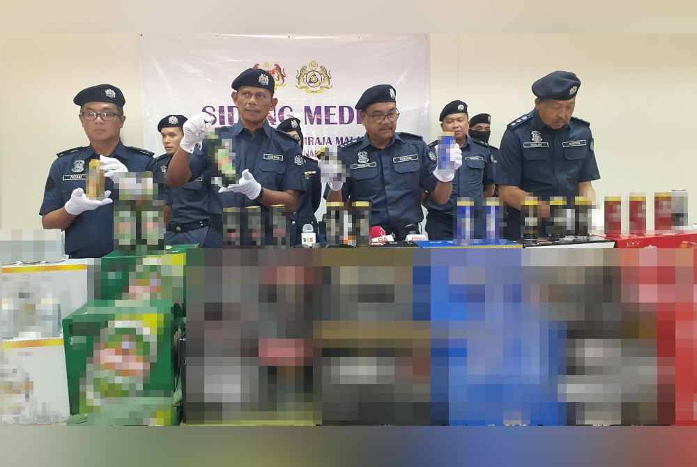 Roselan (tiga dari kanan) bersama pegawai JKDM Pulau Pinang menunjukkan sebahagian minuman keras yang dirampas.