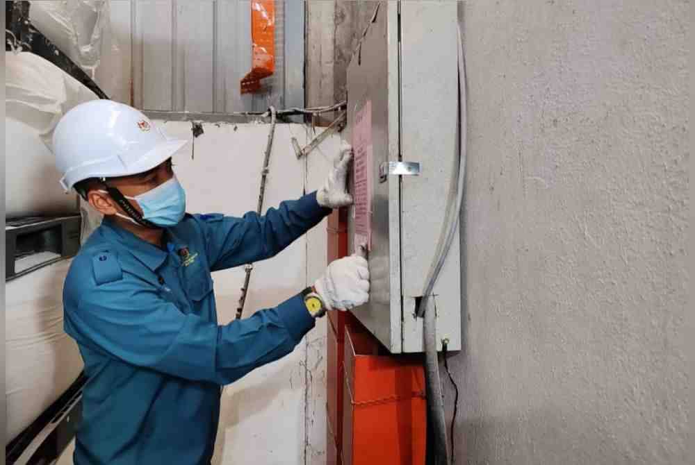 
Kakitangan JAS meletakkan notis Penahanan Operasi Kelengkapan ke atas premis yang diperiksa. Foto JAS