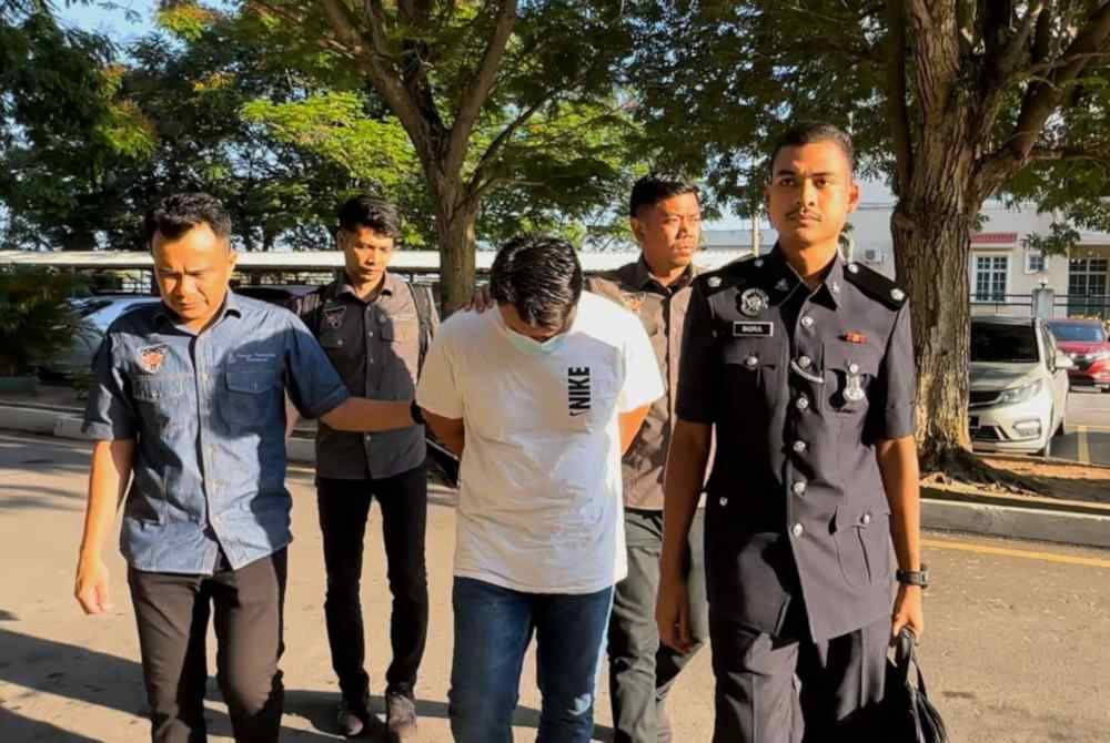 Tertuduh (kiri, depan) diiringi pegawai polis ketika hadir ke Mahkamah Sesyen Butterworth pada pagi Khamis.