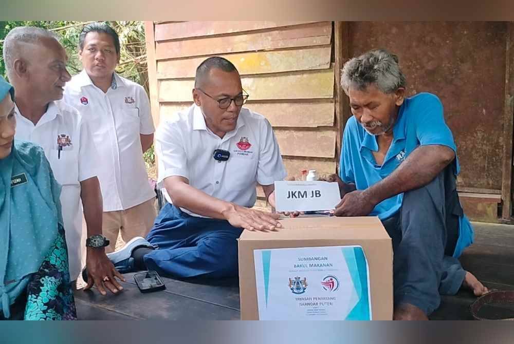Pandak (dua dari kanan) menyerahkan sumbangan kepada Zainuddin ketika program ziarah kasih di Kampung Pekajang, pada Khamis.