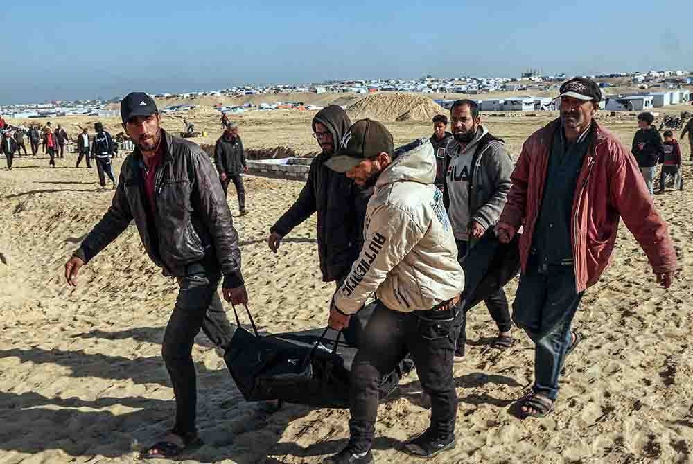 Orang ramai membawa mayat penduduk yang terbunuh semasa serangan Israel untuk pengebumian di tanah perkuburan di Rafah di selatan Semenanjung Gaza. Foto AFP