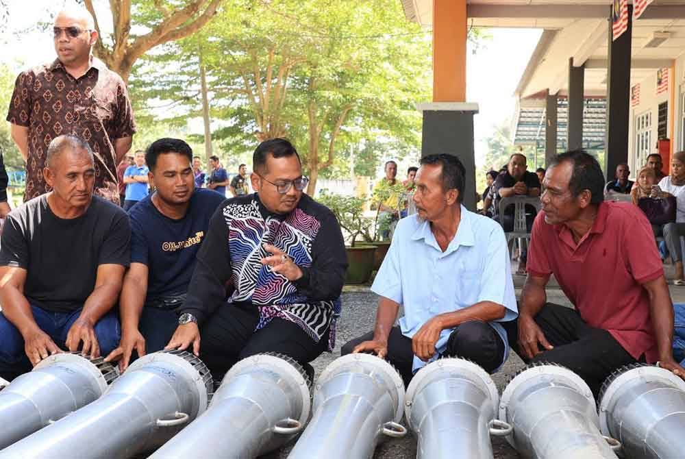 Mohd Faizul (tengah) menerangkan sesuatu kepada peserta yang hadir pada Majlis Penyampaian Pam 'backward' di Pejabat KADA Jajahan Kota Bharu Selatan.