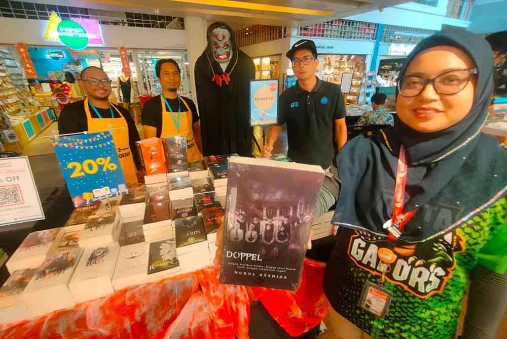 Nurulasikin (kanan) menunjukkan koleksi novel dijual pada harga diskaun hebat.