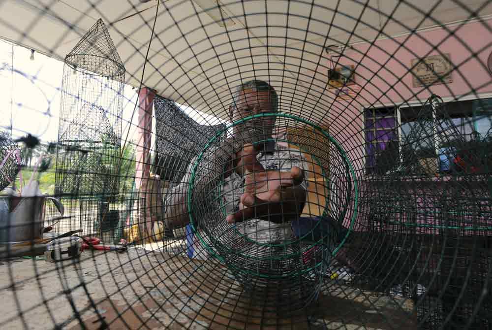 Nor Mohamad membuat gerogoh menangkap udang menggunakan besi dawai. Foto Bernama
