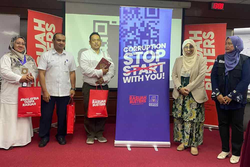 Mohd Salleh (tiga dari kiri) menerima cenderahati daripada Nurhayati (dua dari kanan) sebaik sahaja tamat program.