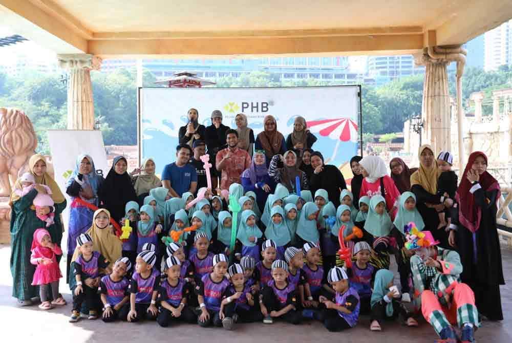 Muhammad Zikri (baju merah, tengah) bersama kakitangan PHB dan penghuni Rumah Amal Al-Firdaus sempena program Waves of Joy di taman tema Sunway Lagoon, Petaling Jaya pada Khamis.