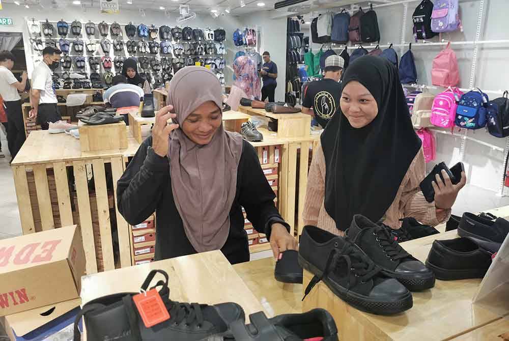 Zalina (kiri) bersama anaknya, Nur Ain Syakira memilih keperluan persekolahan ketika 'program Kembali Ke Sekolah ' anjuran Fisabilillah Terengganu.