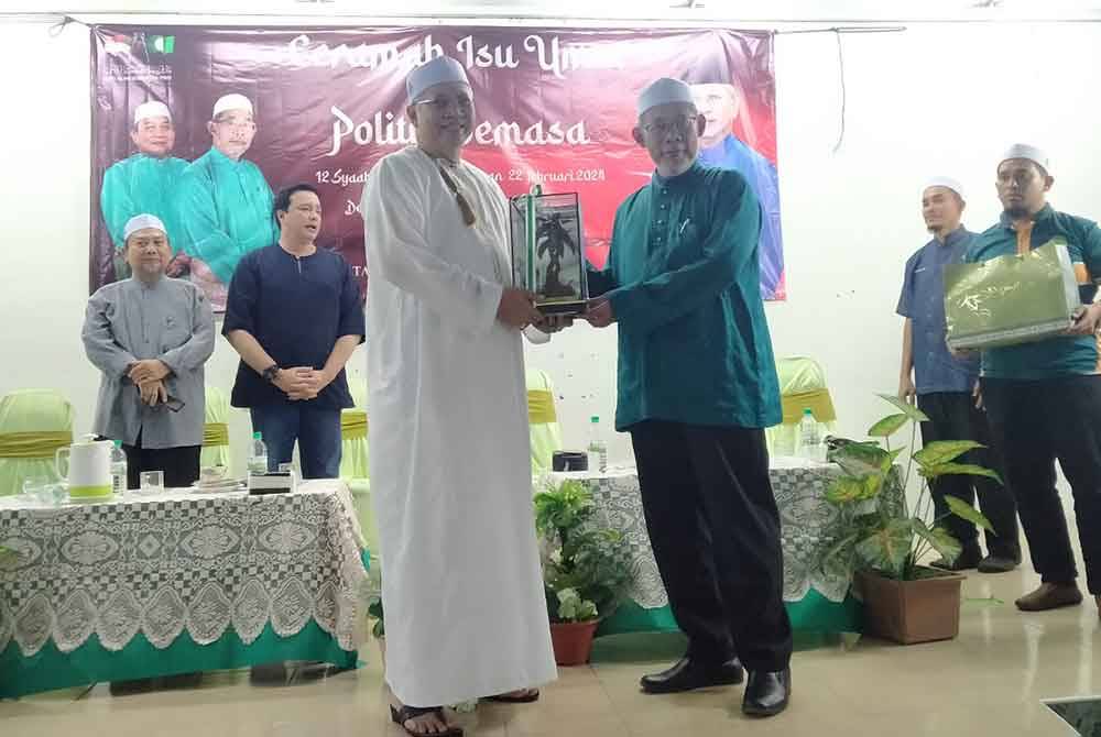 Annuar (kiri) menerima cenderahati daripada Misbahul Munir selepas Ceramah Isu Umat dan Politik Semasa di Dewan Besar Markas Pas Kawasan Bagan Datuk, Selekoh di sini pada malam Khamis.