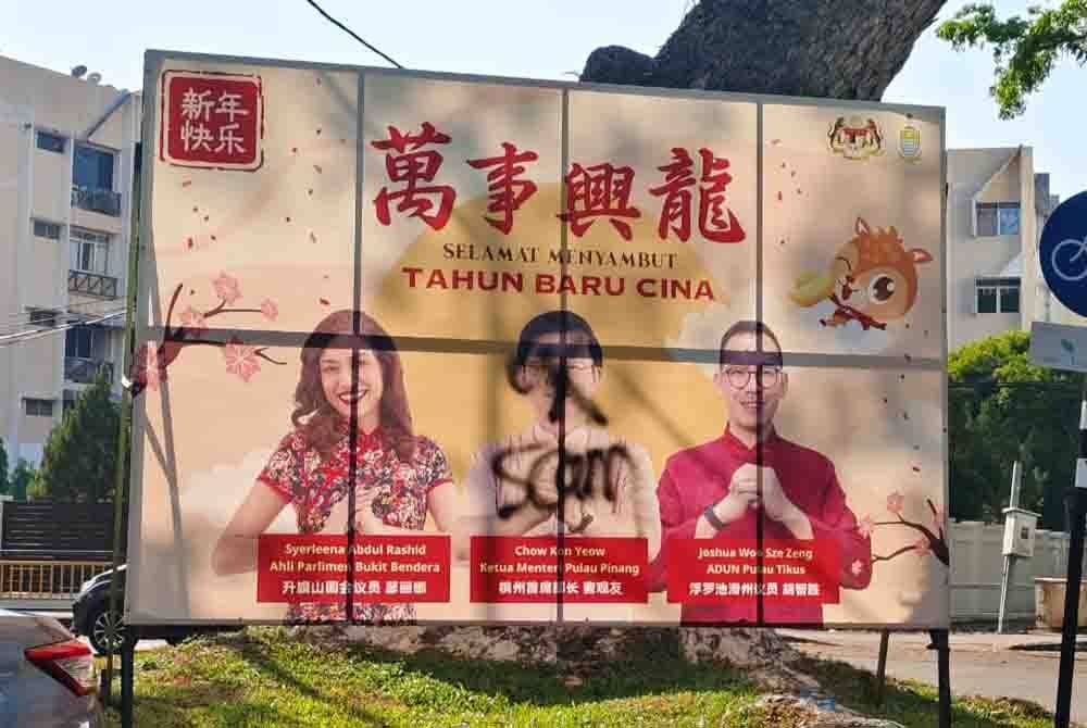 Gambar Kon Yeow pada papan iklan Tahun Baharu Cina yang diconteng dengan cat berwarna hitam.