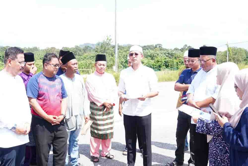 Mohd Fared ( tengah) melihat keadaan bumbung salah satu blok bangunan di Sekolah Agama ( SA) Kampung Sawah, yang dilanda ribut, di Pontian.