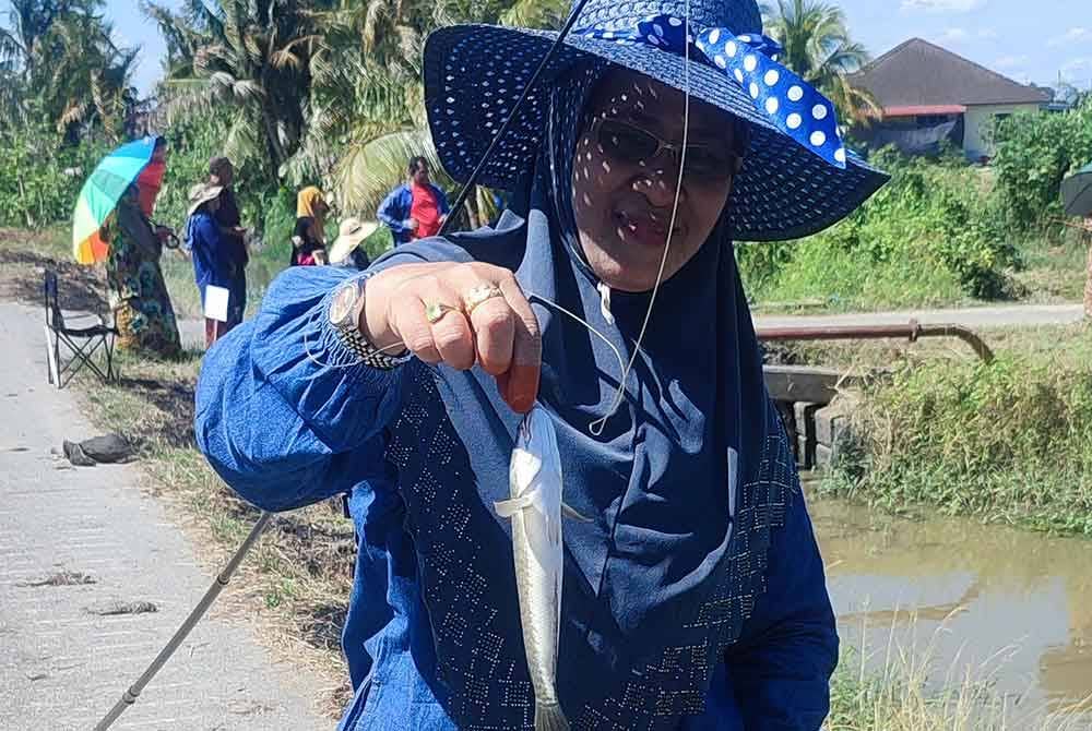 Kalijah menunjukkan hasil tangkapan ikan di tali air di Kampung Alor Serdang.