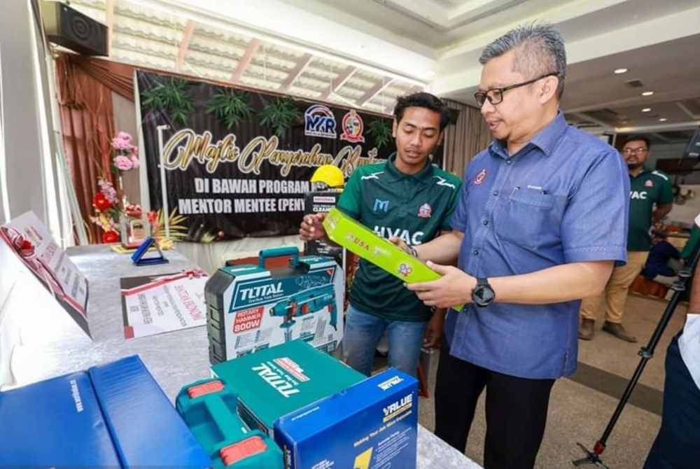 Ismasuhaimi (kanan) melawat ruang pameran peralatan disediakan mentor untuk program berkenaan.